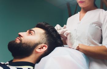 Man undergoing nonsurgical hair restoration treatment.