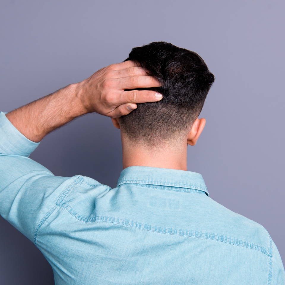 Rear back view of attractive cool confident content man wearing blue formal shirt good haircut touching shine fresh clean hair isolated over pastel grey violet background